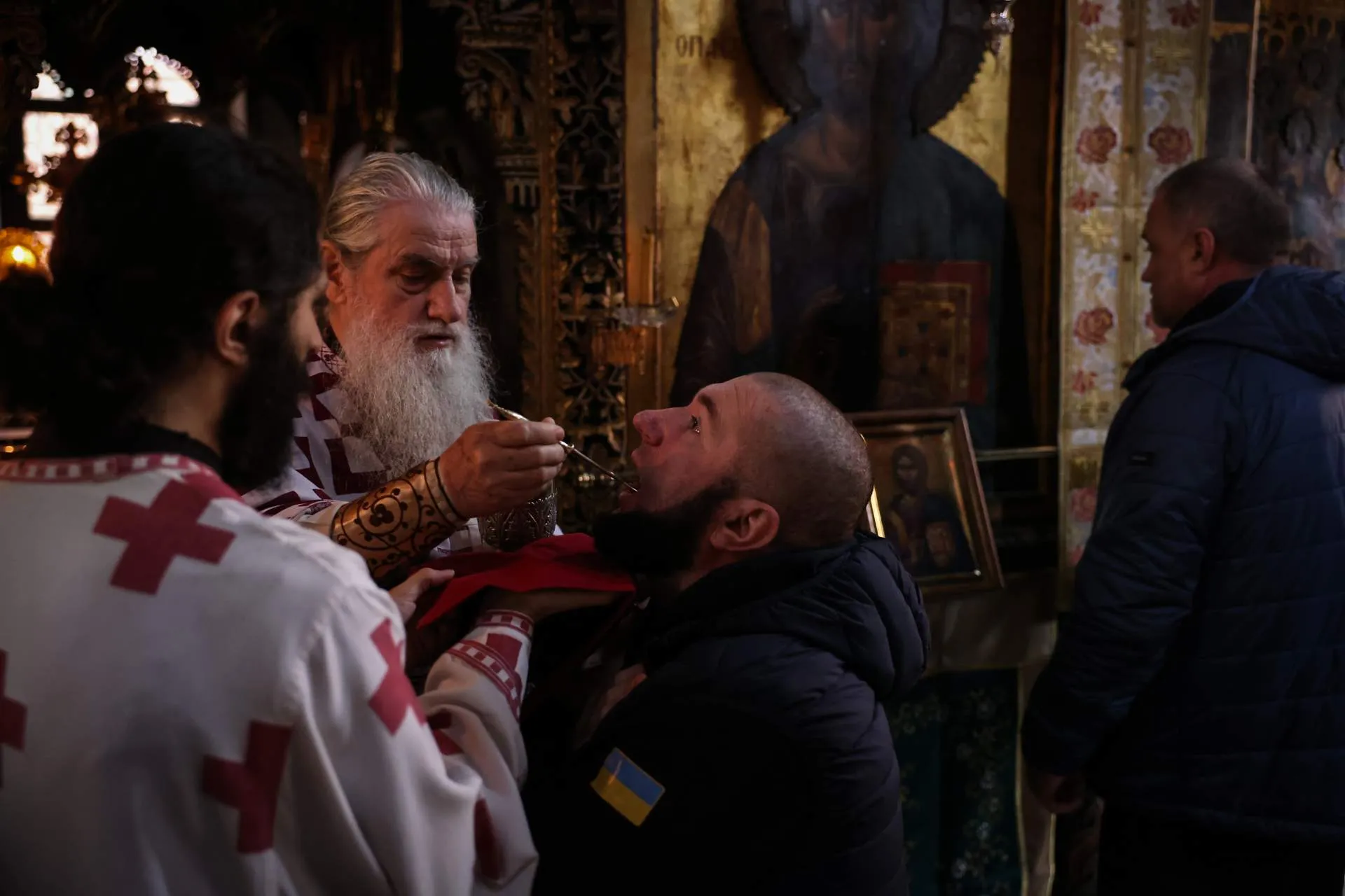 Військовий розвідник Володимир Яхторович, 41 рік, причащається отцем Епіфанієм під час богослужіння в храмі монастиря Пантократор на горі Афон, Греція, 26 листопада 2024 року